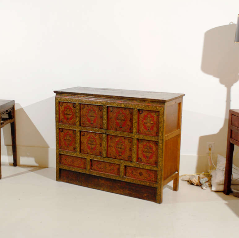 A pair of monastic cabinets, each decorated with gold leaf over finely detailed animal bone gesso.  Each panel depicts an ornate offering bowl, in lotus presentation, overflowing with emblems representing offerings to the senses and previous
