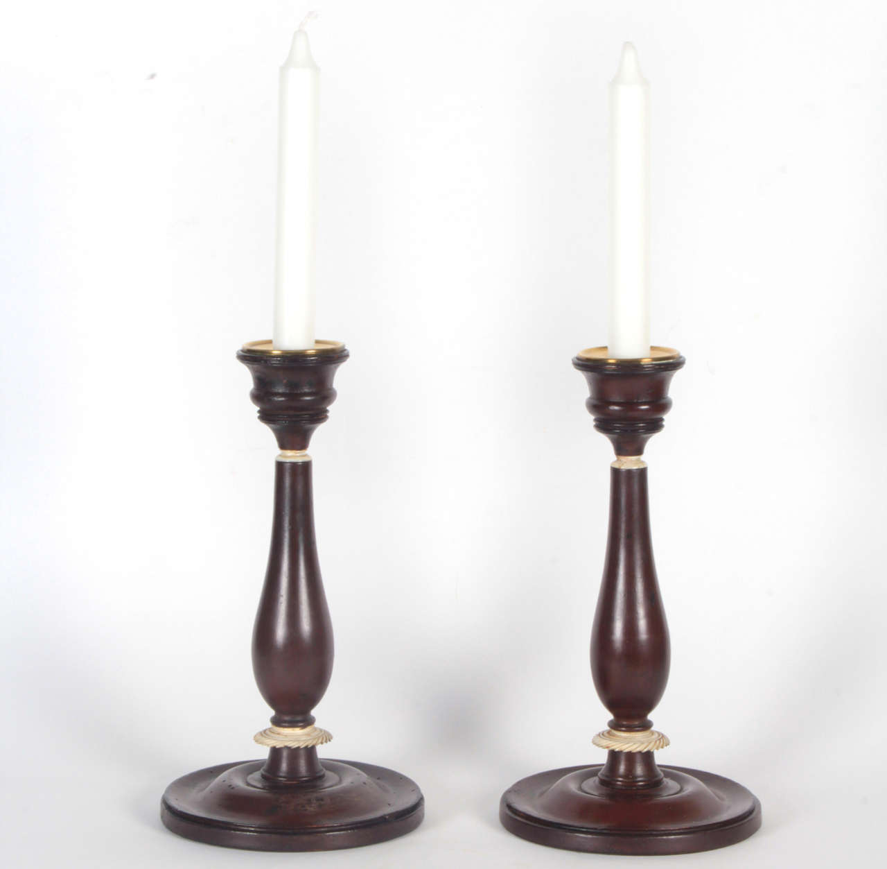 A pair of Danish Empire painted and bone candlesticks, circa 1810, of baluster form carved bone bandings and a circular base.