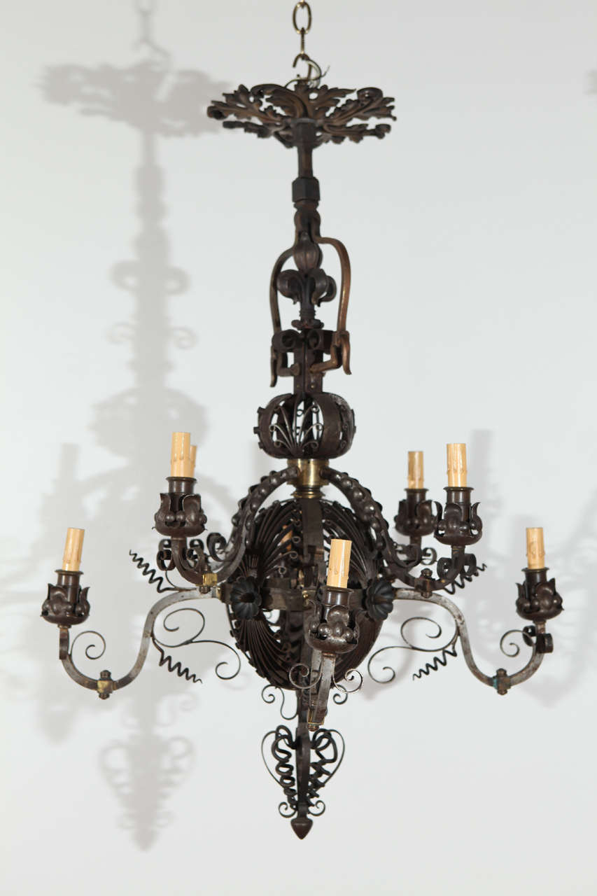 Raffinato lampadario a cinque bracci in ghisa con dettagli in bronzo.  Firmato 