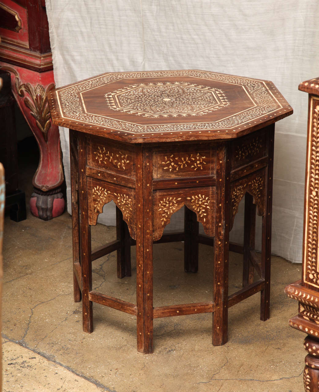 An octagonal wood side table with intricate design of bone inlays in a classic Indian style. Two pieces with a folding base.