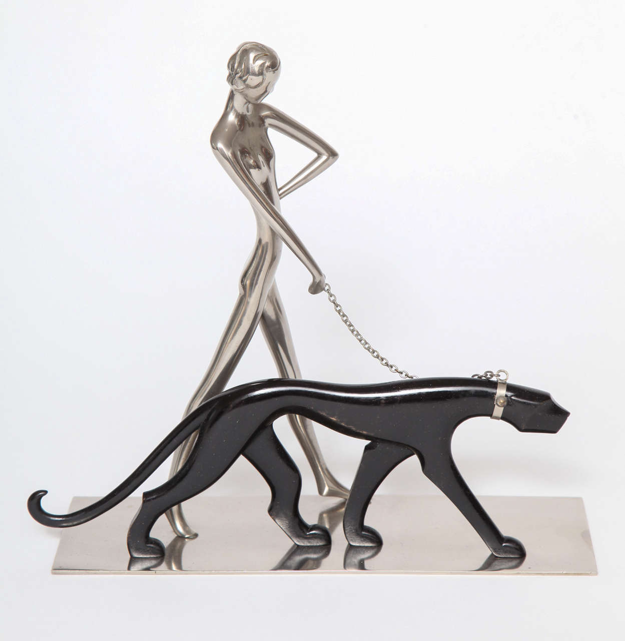 A Hagenauer sculpture of a nickel-plated brass nude woman walking a carved wood panther, 1928, Austria. Marked on underside of base.