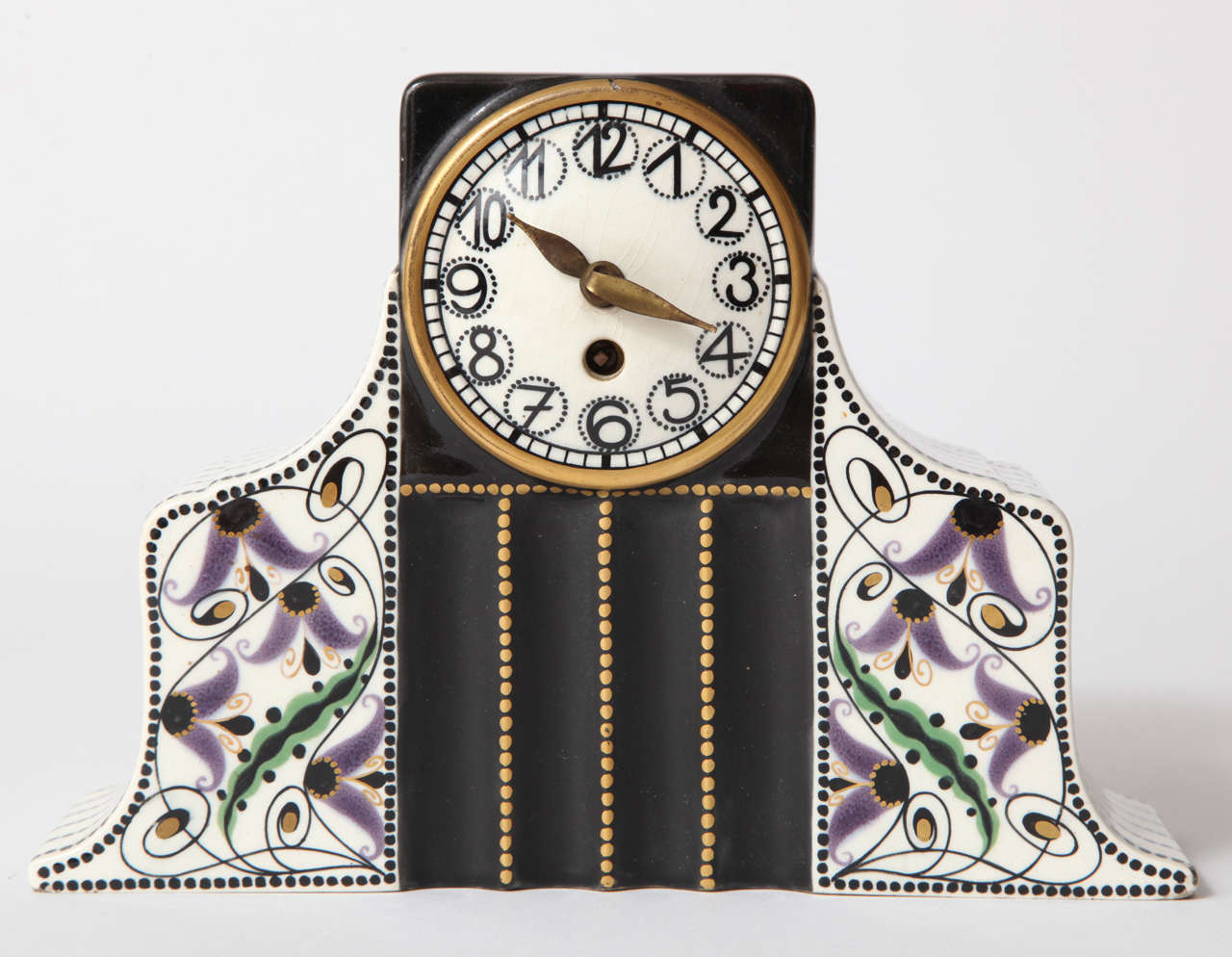 A hand-painted and glazed earthenware Serapis Wahliss clock with a highly stylized multi-colored floral design against a black, white and gold background.
