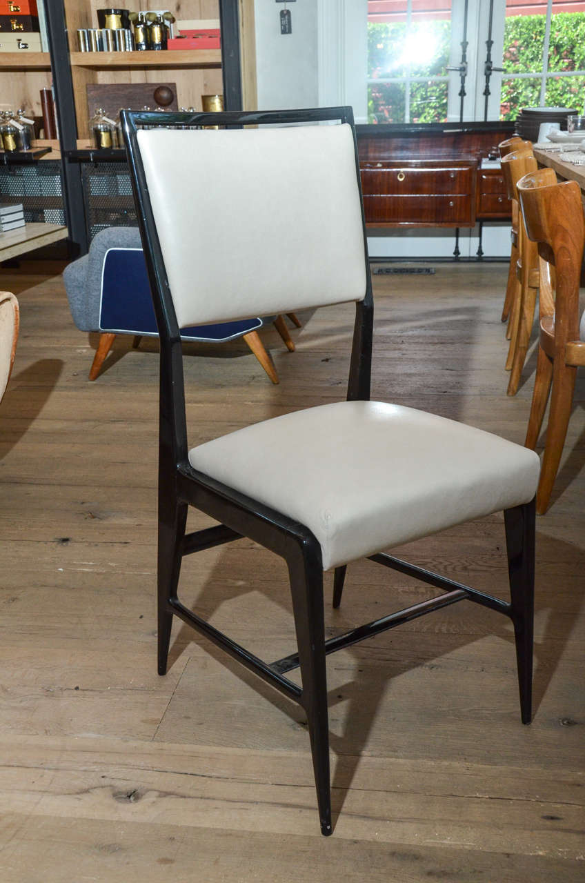 Stunning pair of occasional chairs attributed to Gio Ponti newly re-upholstered in oyster color calfskin leather contrasting beautifully with the black color frame and legs.