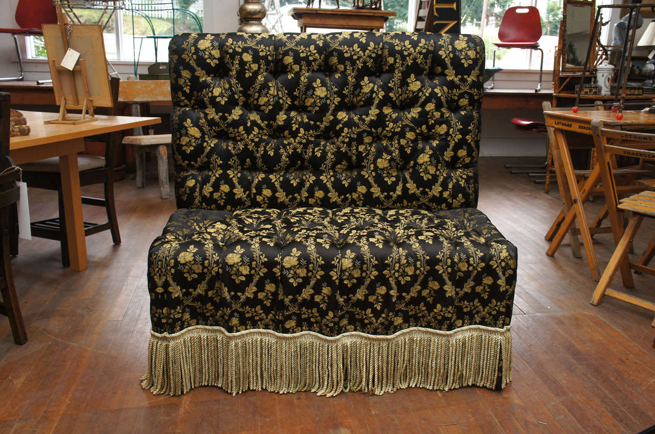 Victorian-style upholstered and tufted banquette with black
and gold (yellow ochre) fabric and deep matching fringe.
Upholstered legs.