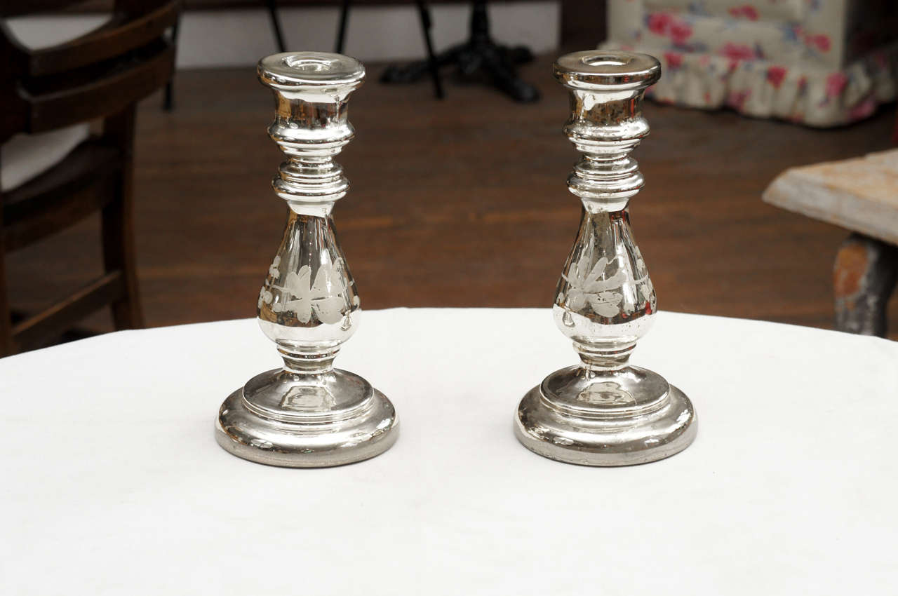 Pair of mercury glass candlesticks floral decoration around center of each
candlestick, circa 1850.
