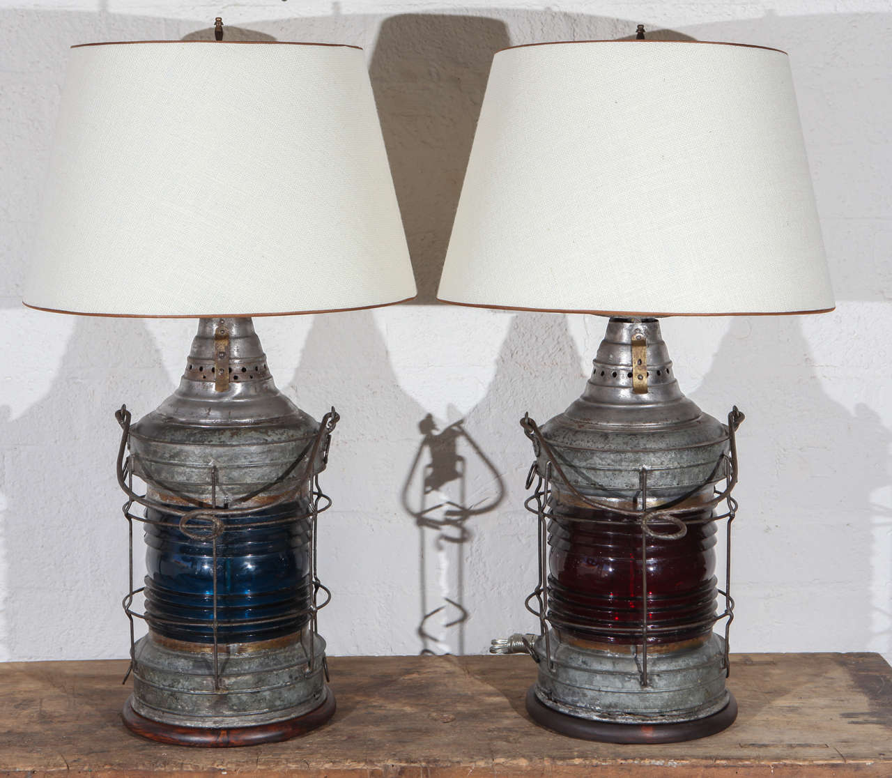 These are truly unique lamps made from ship lanterns, one with a red glass barrel for the port side and one blue for the starboard side. A closer look reveals a fuel feed, indicating that the lanterns were oil burning originally. These lamps are of