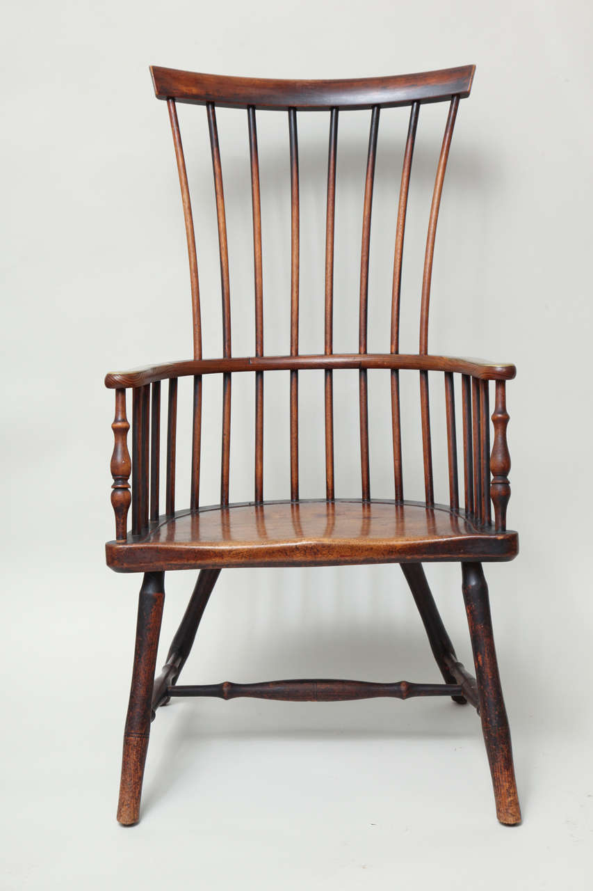 Very fine early 19th century Scottish Windsor comb back armchair, the simple crest over spindle back, the arms with brass capped ends, over shallow dished 