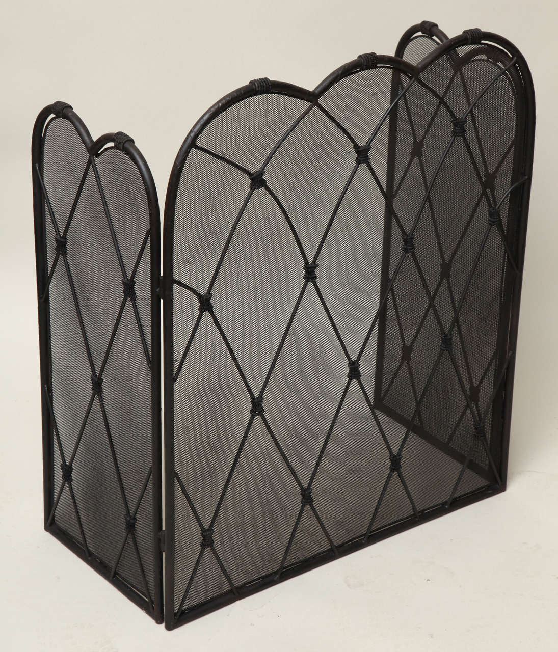 Early 20th century wrought and spring iron folding fire screen (firescreen) crafted from coiled black iron, of trefoil form with three lobes to central panel and double-lobed wings, all with diamond paned faces having intersections tied with coiled