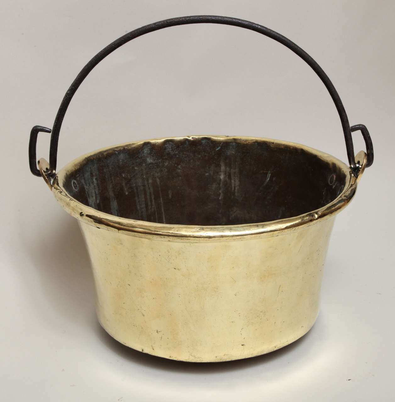 Late 18th or early 19th Century English brass cauldron, having rolled lip, wrought iron handle and copper rivets, the body with hand hammered decoration, the gently concave body having rich mellow glow.  Ideal for log bin or kindling bucket.