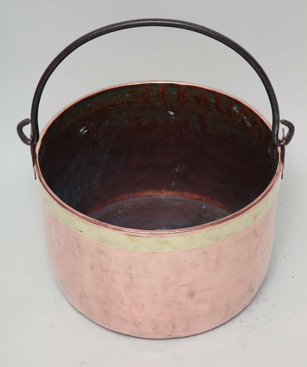 Mid-19th century copper bucket with wrought iron loop handle and brass banding, hand-hammered surface and nicely polished. 

Log holder, planter and firewood container.