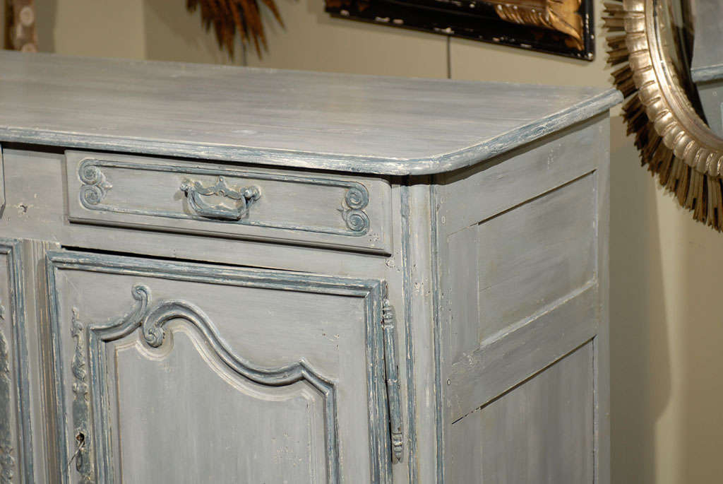 19th century French Provincial paint decorated light blue buffet, the rectangular top surmounting two drawers and a double door cabinet, opening to reveal two shelves and raised on scrolling feet. 