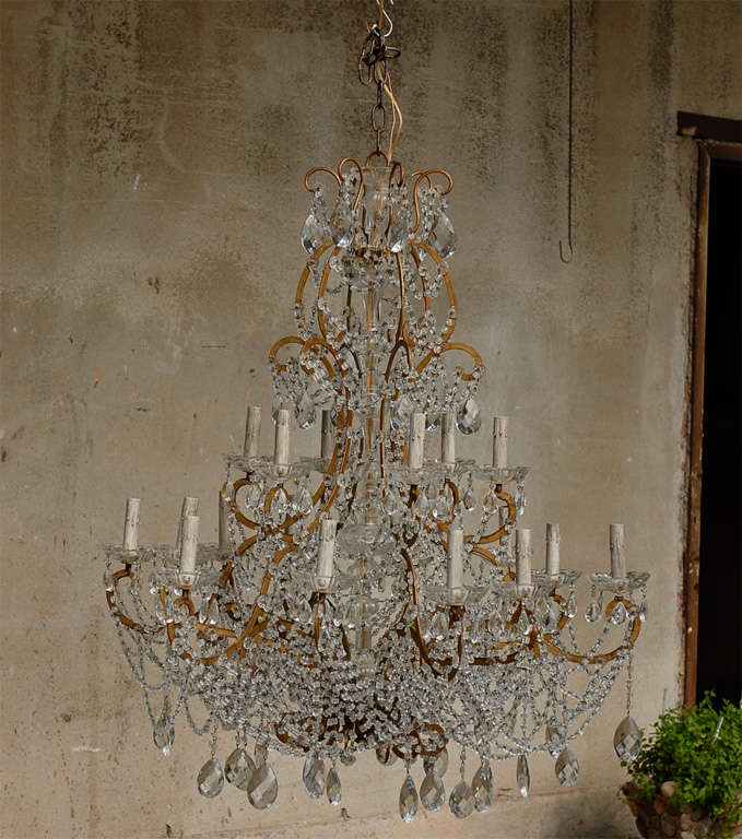 A Beautiful Mid 20th C. Italian Crystal Chandelier. Rewired with Custom Chain. 18 lights on 2 levels. At the lower level, the lights' arms alternate in width, giving a lot of life to this chandelier.

This crystal chandelier has been rewired for