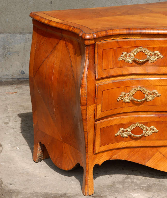 An 18th century Swedish period Rococo Serpentine chest of three drawers.  This antique commode from Sweden has a shapely serpentine body with beautiful elm veneer.  The skirt is heavily scalloped and this piece is presented upon cabriole legs.  Each