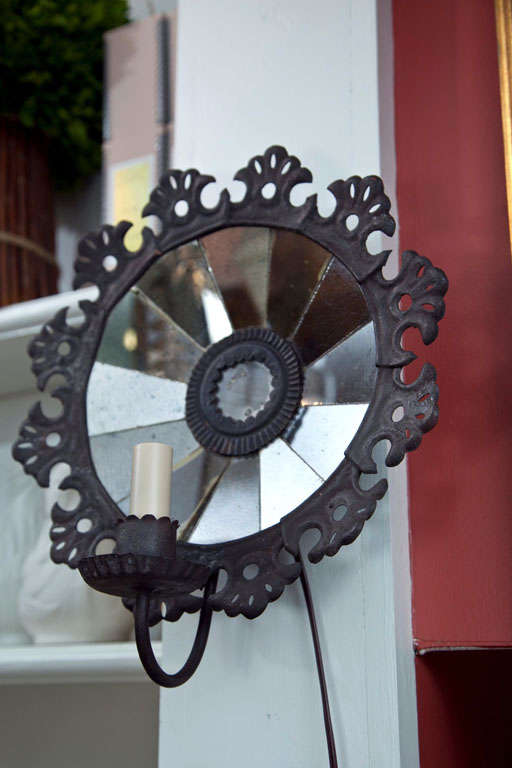 Panels of mirrored glass are set in a concave arrangement to create ambient reflected light.  Decoratively pressed tin surrounds the back of the sconce to give the effect of lace.  All new wiring for US candelabra bulb.