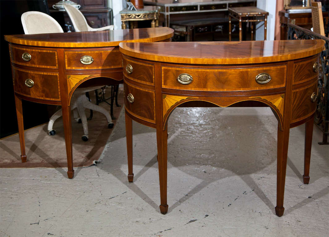Pair of charming English Georgian style demilune console tables, circa 1940s, solid mahogany with satinwood marquetry and banding, the shaped halfmoon top over a bow-shaped conforming case fitted with five drawers, the center with double domed arch