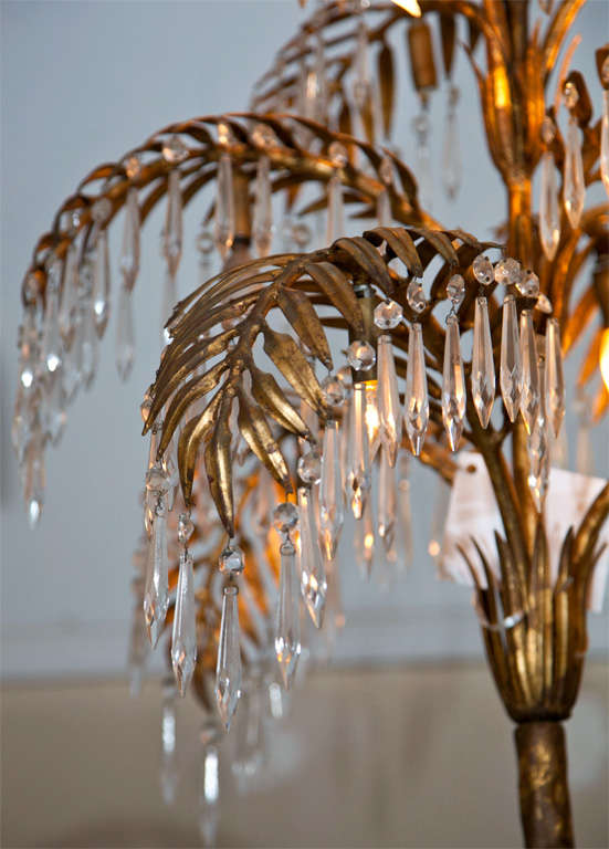 French Hollywood Regency style brass palm-tree leaves chandelier, circa 1940s, each leaf has crystal prisms hanging from the tips. A very chic chandelier!