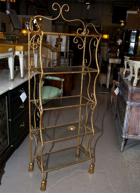 A charming French gilt-brass etagere, five tiers with glass tops, the brass shapes like rope, tassel-like base.