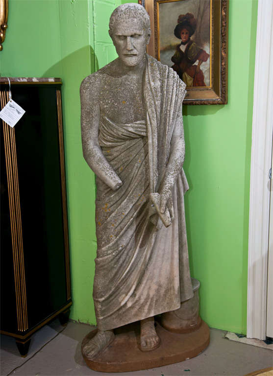 This life size figure of a Roman Statesman, Demosthenes, is made of solid marble. Wonderfully weathered and detailed as is seen in his robe holding a law scroll. Missing part of the arm and lower left hand.