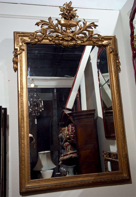 Ein feiner französischer, geschnitzter und wasservergoldeter Spiegel mit Blumen- und Urnenmotiv, mit Perlenrand und ineinander verschlungenen Glockenblumen.