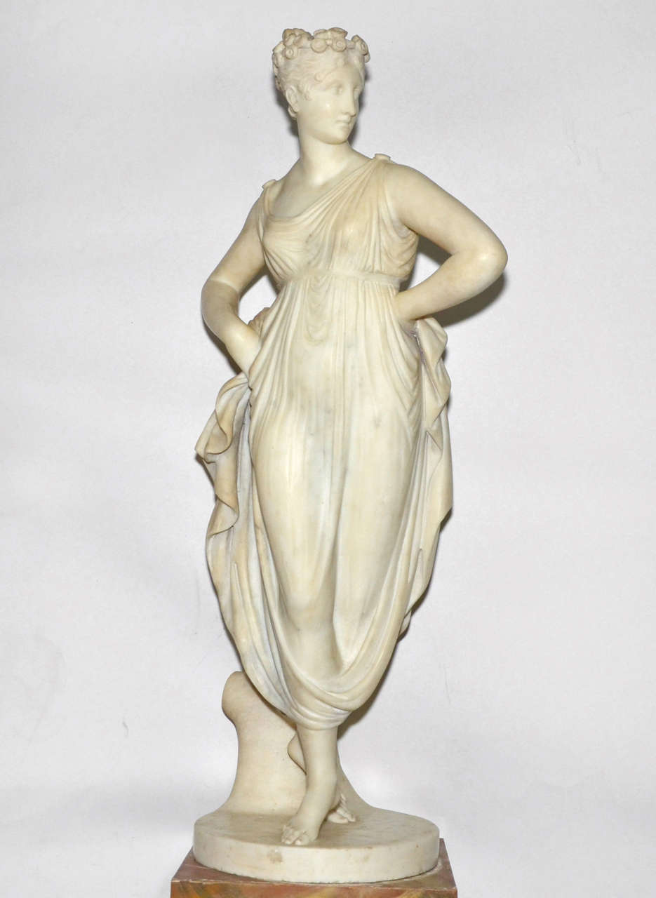 1820s Carrara marble statue of a draped woman. Can be sold with a pedestal in wood imitating marble. Some chips off the surface of the marble. Normal wear consistent with age and use. Statue with pedestal: height 120 cm., length and depth 34 cm.