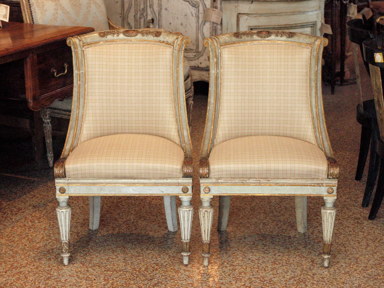 Pair of 19th century small directoire painted chairs with
gondola back and saber feet.  Gray green painted and gilded with a wood carved applique on the crest of the chairs.
Newly upholstered.
