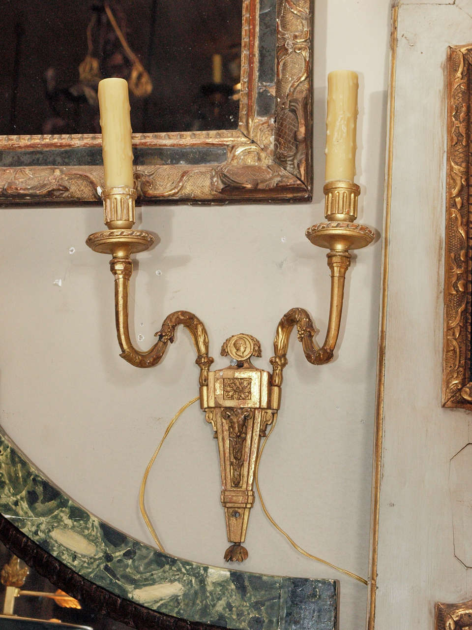 Amazing pair of Italian Gilt Wood Sconces.  The back gilt plate is carved with a medallion at the crown over a rosette and a ram's head.  US wired.