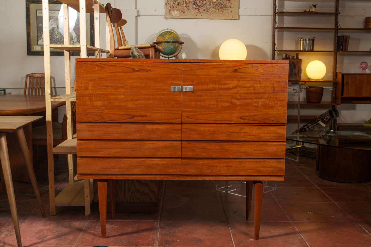 Rare Teak sideboard by H.W. Klein, produced by Bramin, Denmark. Behind it's top two doors are a pair of adjustable shelves, below are six drawers with Green felt lining
This credenza/sideboard has beautiful craftmanship and detail, starting at it's