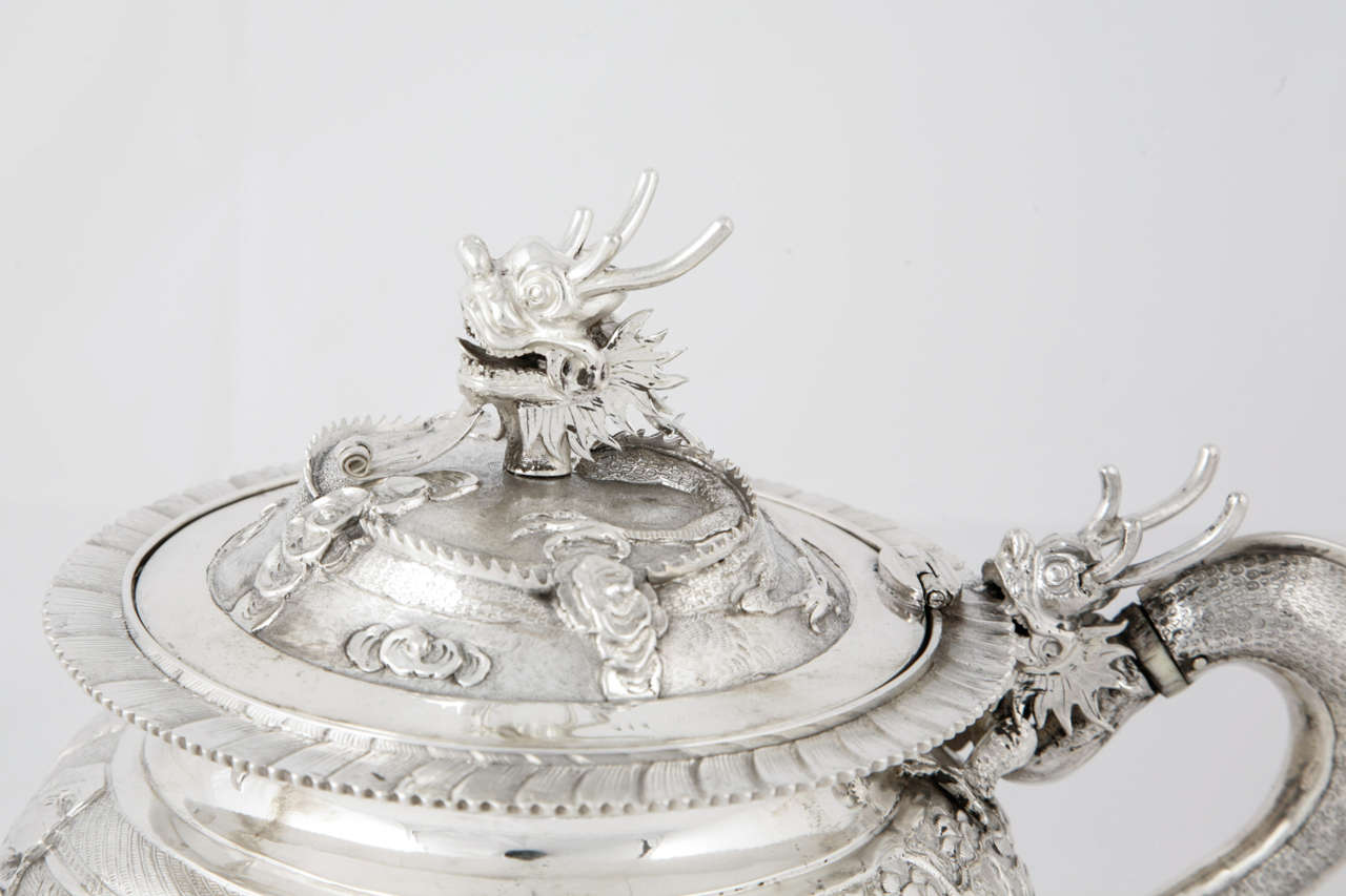 A Chinese Export Silver 3 Piece Teaset  each piece with embossed and chased figural scenes. The teaset has dragon handles and finials. 
The teapot is marked for Wang Hing and the sugar and cream are unmarked. 
This set dates from around 1880.