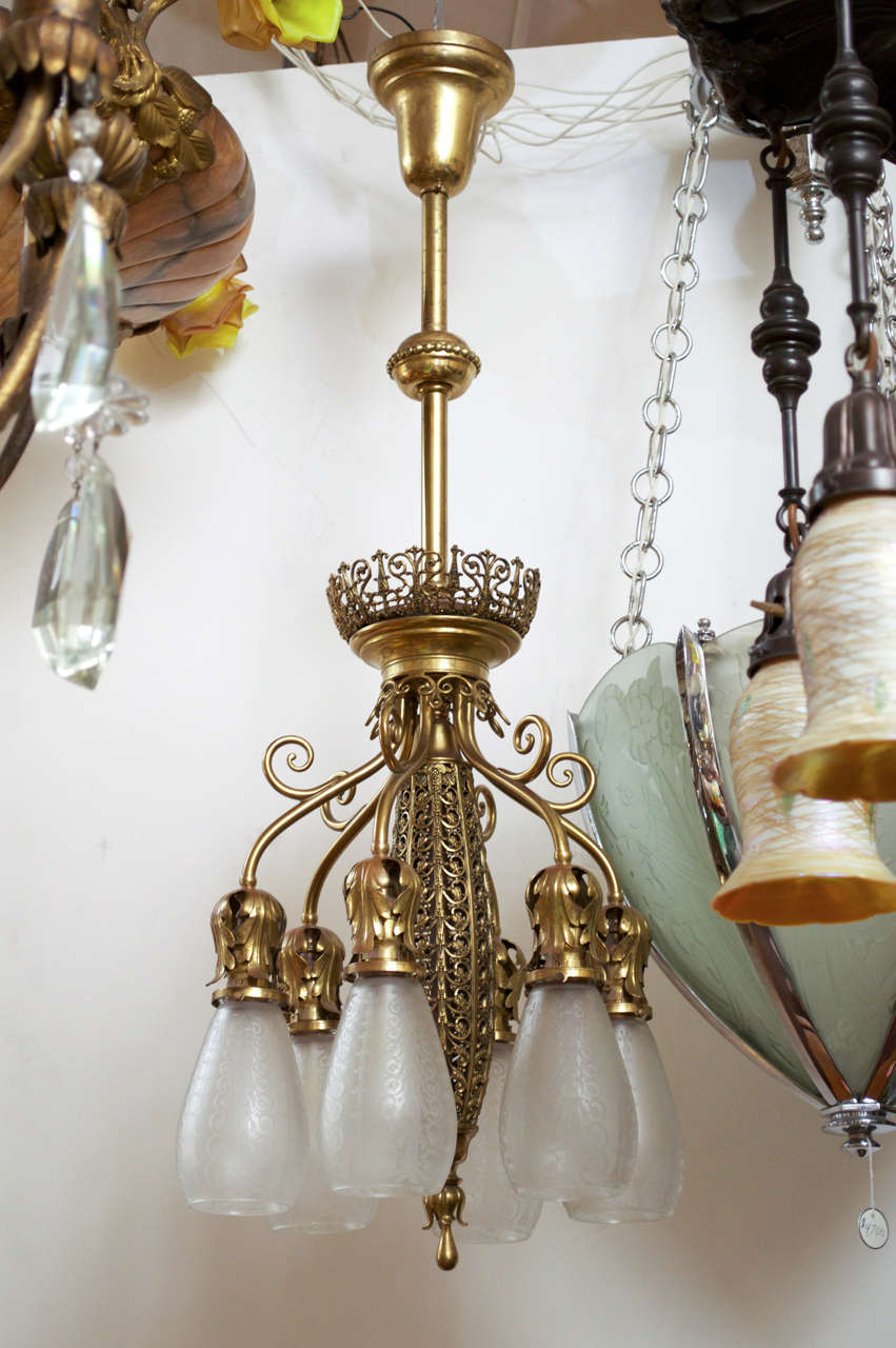 This elegant fixture represents one of the most sought after lighting styles of the late 19th Century.  The beautiful filigree brass work coupled with the matching deep-etched original glass shades really make for a gorgeous piece of lighting.  Note