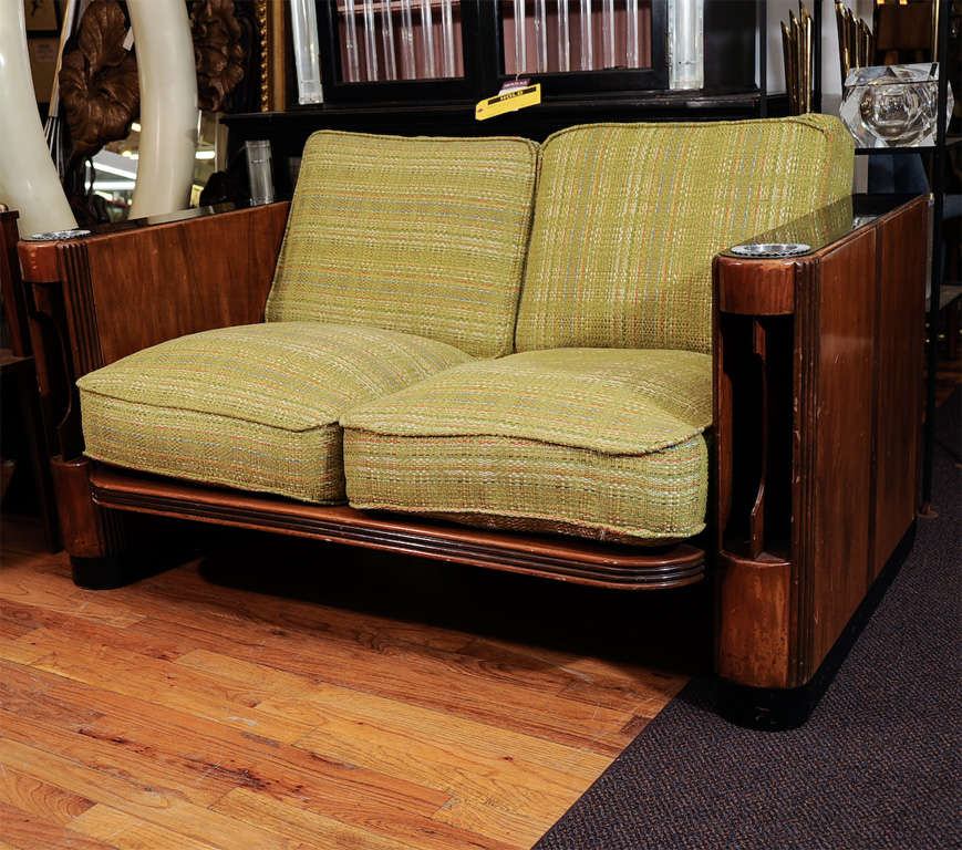 A custom American Art Deco love seat with inset Bakelite armrests incorporating chromed bronze ashtrays and wooden magazine racks. Made by the Chase Company. Petite walnut frame with original tweed fabric upholstery in lime green.