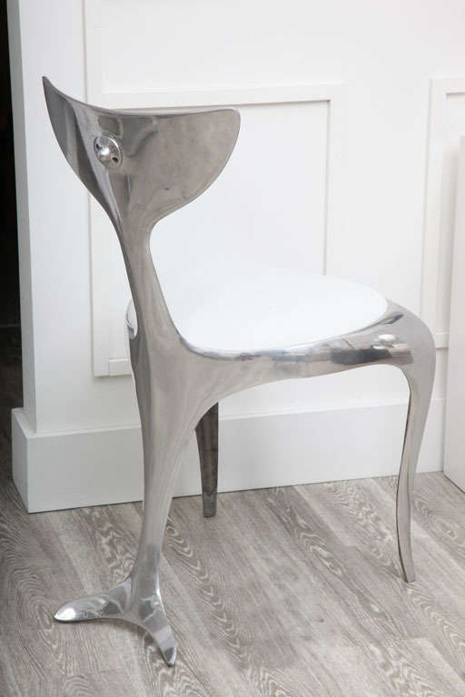 Dolphintail Chair Mark Brazier Jones Limited Edition chairs. Polished aluminium with white linen upholstery. A total of 3 chairs, individually priced at $3000.