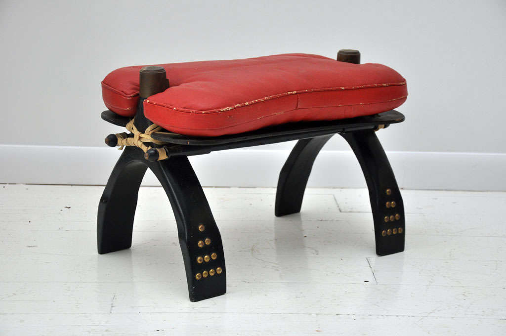 Wood with decorative studs and red leather cushion.