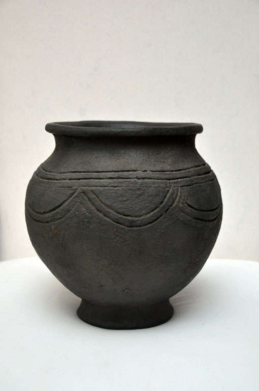 Carved African pot with footed base.