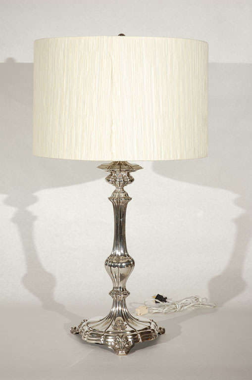 This fanciful silver plated cast metal table lamp with foliate motifs and stylized finial is a real beauty.  Lamp has a new pleated silk shade.  Lamp also features four sockets and has been newly rewired.  Base measures 11