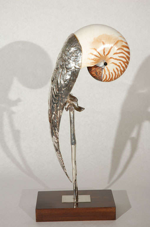 This beautiful Italian hand crafted bird sculpture perched on a custom stand by Gabriella Binazzi was created by integrating a polished nautilus seashell as the head into a hand chased silver plated metal body.  Piece is signed Banazzi, Firenze and