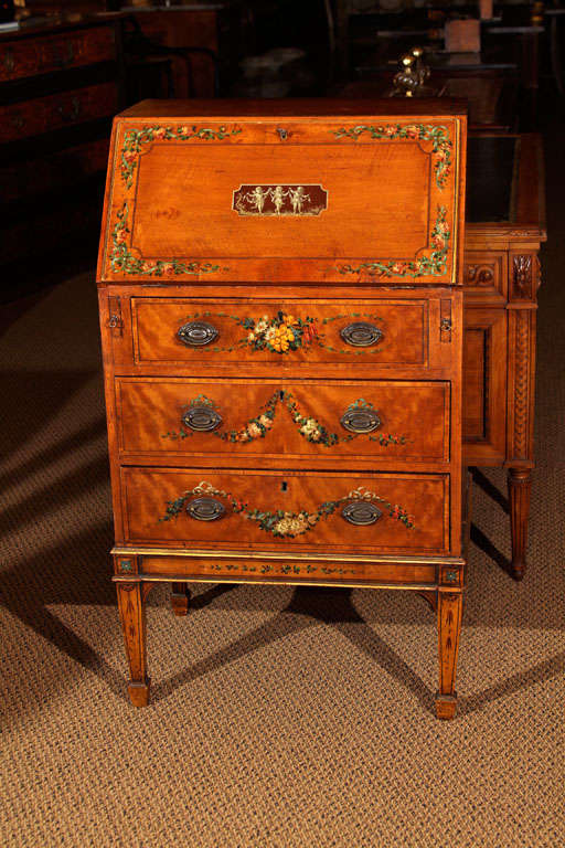 Small English Edwardian Satinwood Bureau

This highly decorative bureau features the original paint and gilt on top of satinwood.

The slant lid opens to reveal a nice plain interior with small drawers and cubbies.  It has the old original lock