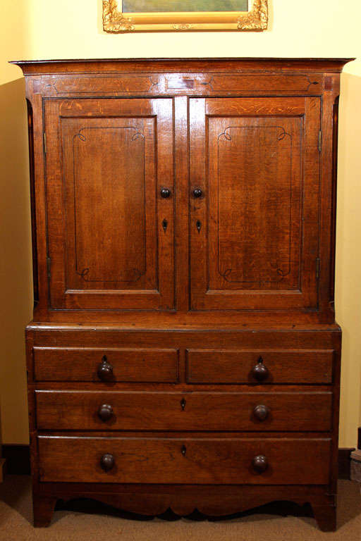 English Oak Linen Press

This is a wonderful, small sized linen press at only 44 inches wide.  It has nice old surface and a soft warm patina.

It features a string and barber pole inlay with ebonized satinwood, walnut and mahogany inlay.

The