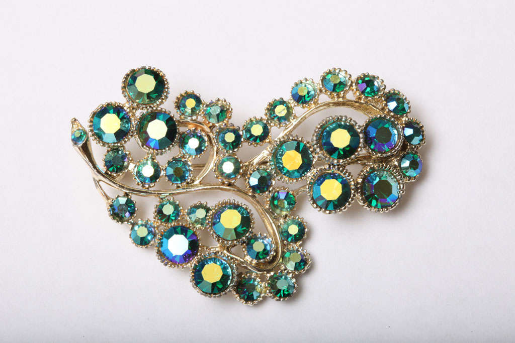 The luscious and stunning colors of this vintage pin are what makes the beautiful crystals of the Aurora Borealis. The brilliant iridescent turquoise to turquoise greens will add to any outfit or coat. It is brilliant with color and would look