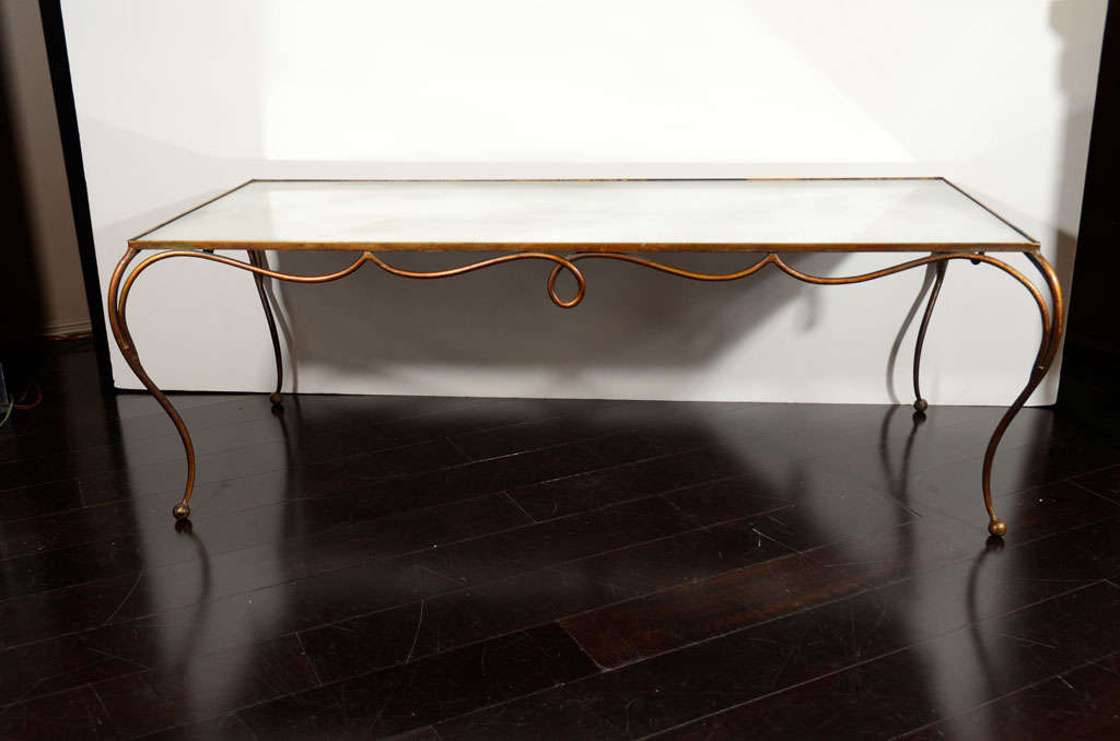 French gilt handwrought iron coffee table has smoked mirrored glass top.