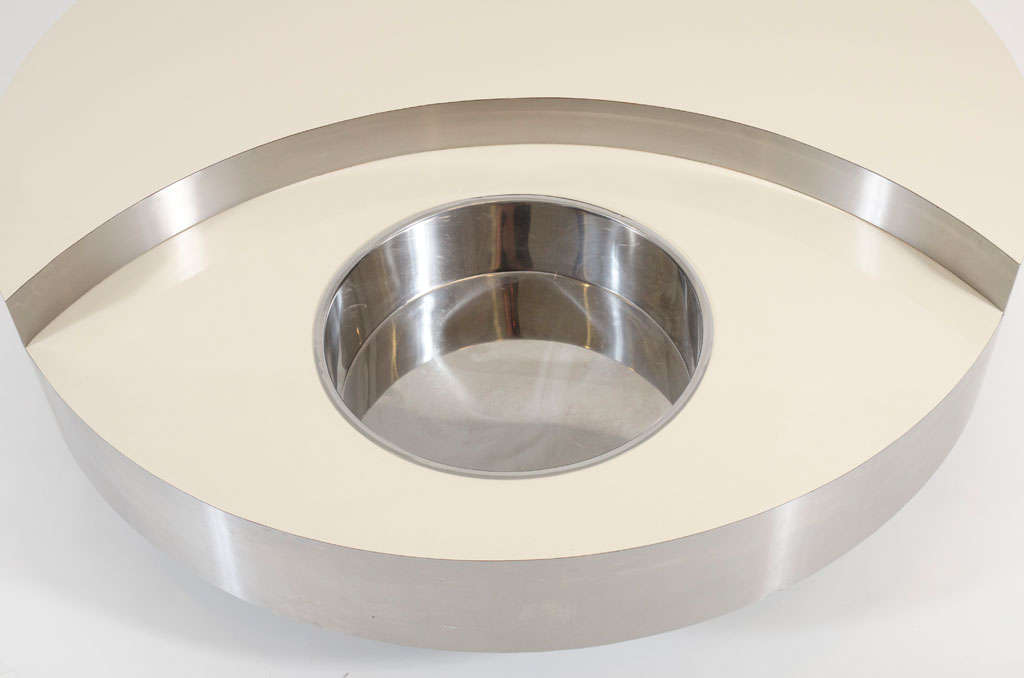A classic mod cocktail table comprising a laminated top, stainless steel apron and bottle chiller, which revolves on a wood plinth base.  By Willy Rizzo. Italian, circa 1970's.