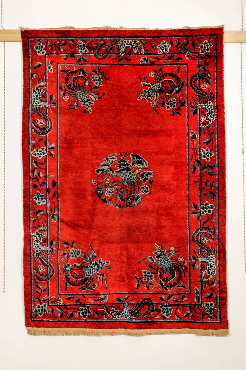 A very rare silk Ningxia carpet with an unusual lacquer red background decorated at the centre by a large phoenix and surrounded by four smaller phoenixes in the corners. The phoenix is the bird of the Empress and symbolizes prosperity and