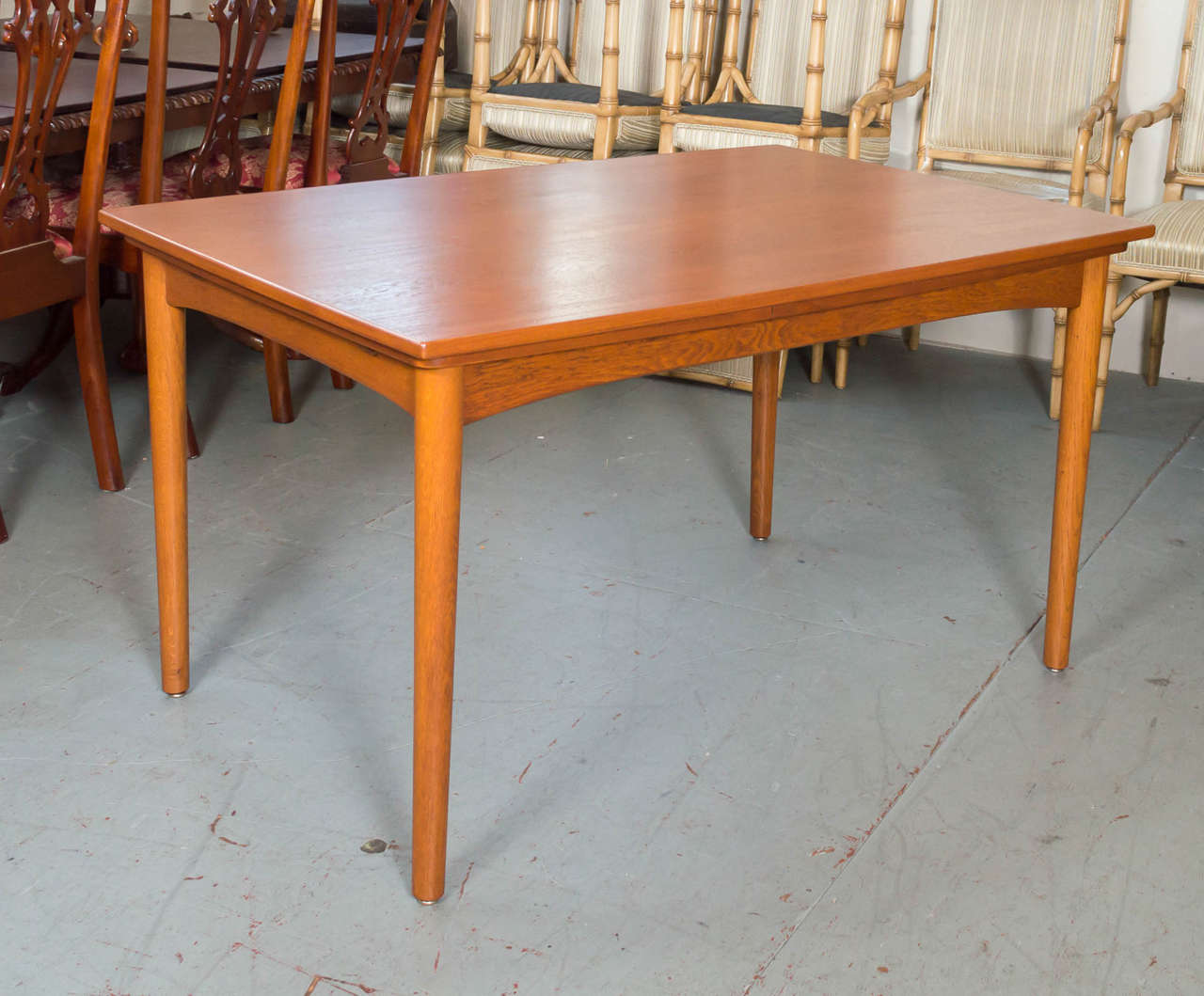 A circa 1950s Danish teak dining table by Arne Hovmand-Olsen for Skovmand & Andersen. It can accommodate small to large groups with it's extendable leaves.
Leaves are 19.50 wide.