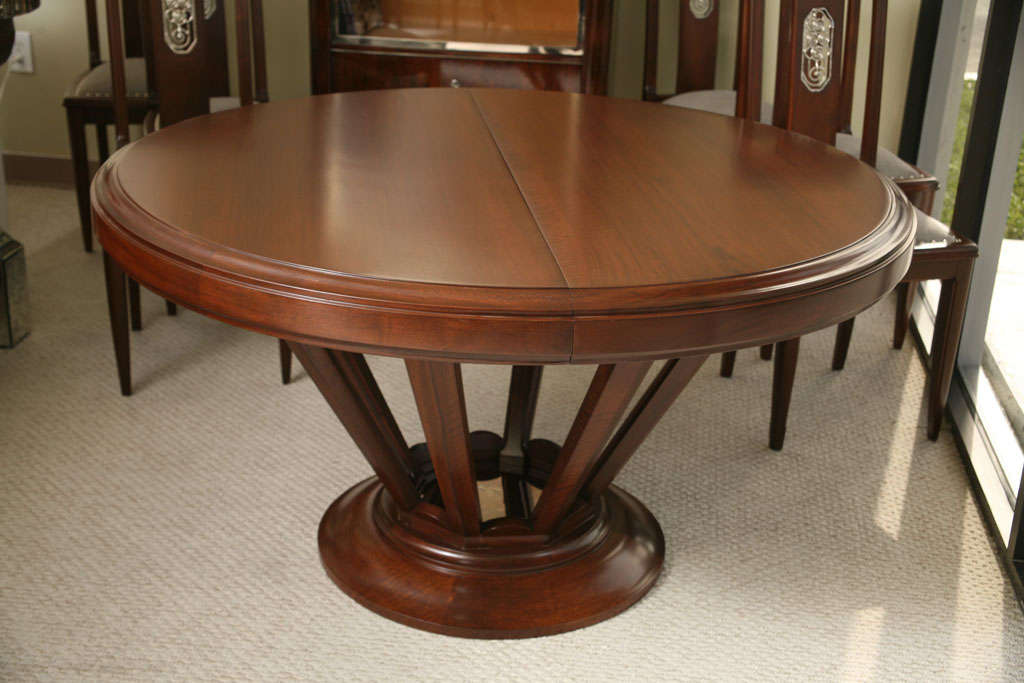 Round dining table Art Deco. The table opens up to 14feet longt!!! 
Made of a beautifully finished walnut. The top stands on eight branches joined to a round base.
One extension 20" has an adjusting edge  with this extension installed , the
