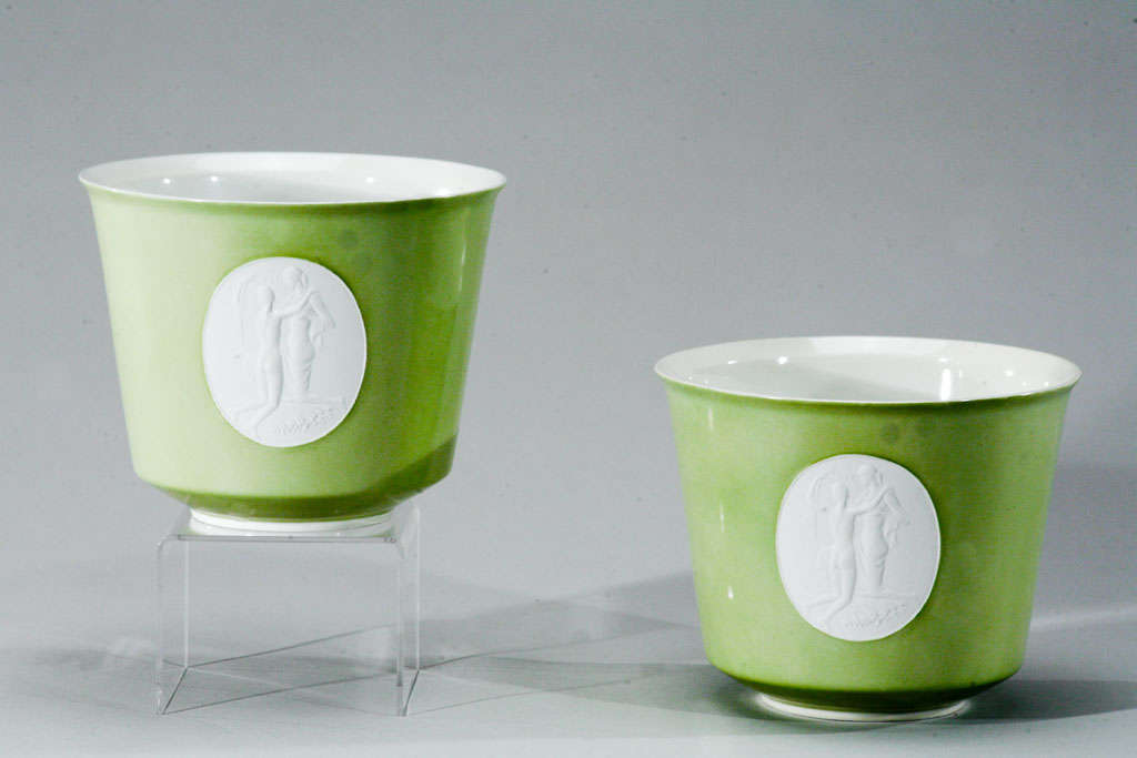 This elegant and simple pair of KPM cachepots each features a parian (unglazed porcelain) medallion of 2 nude women centered on a green glazed ground. Perfect for display as is or filled with orchids or other greenery. The color green is quite