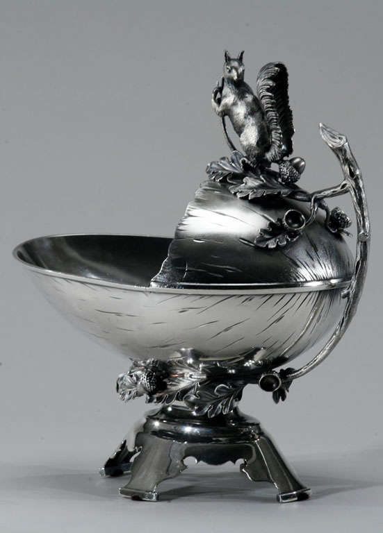 This whimsical Aesthetic Movement silver-plated figural nut bowl is decorated with oak leaves, acorns and branches. Perched atop the bowl is a full figured squirrel keeping a watchful eye. The bowl is shaped like a half of a nut ready to be filled