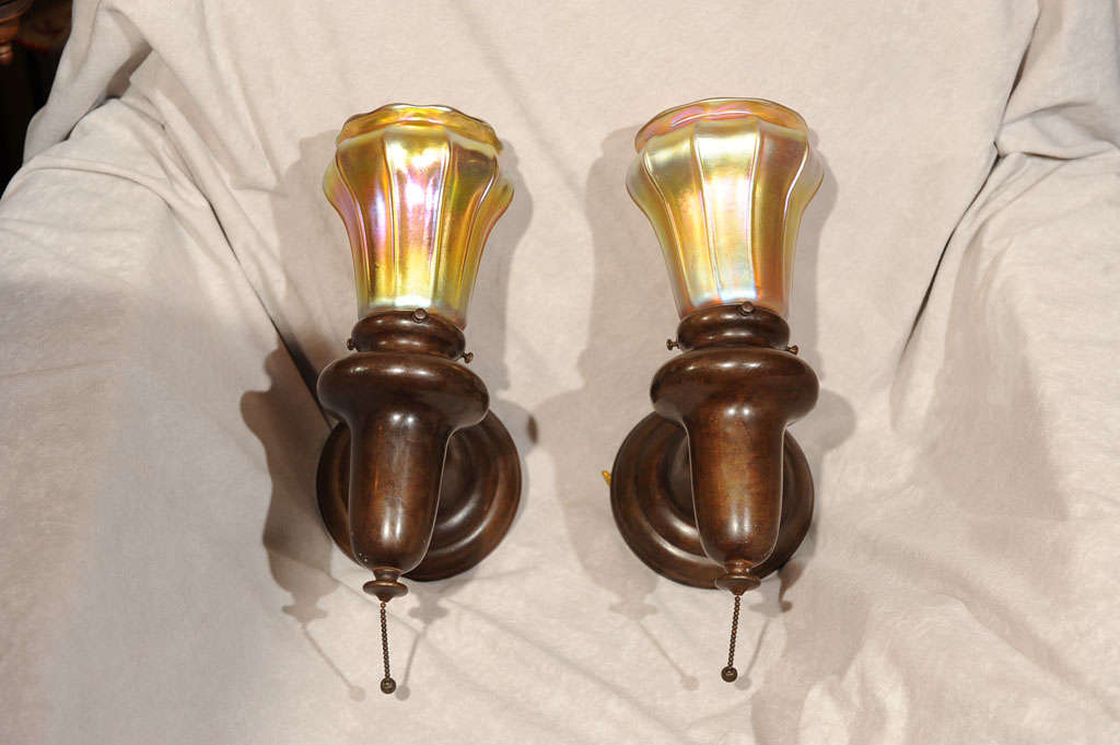 Very handsome pair of patinated brass sconces with gold aurene Steuben shades make a very desirable package. These sconces are very similar to Tiffany's early works and could possibly be Tiffany.  The pull chains (not included in height measurement)