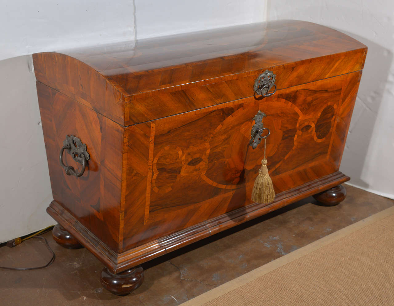 A continental mahogany and marquetry coffer with domed top and bun feet.  18th century.