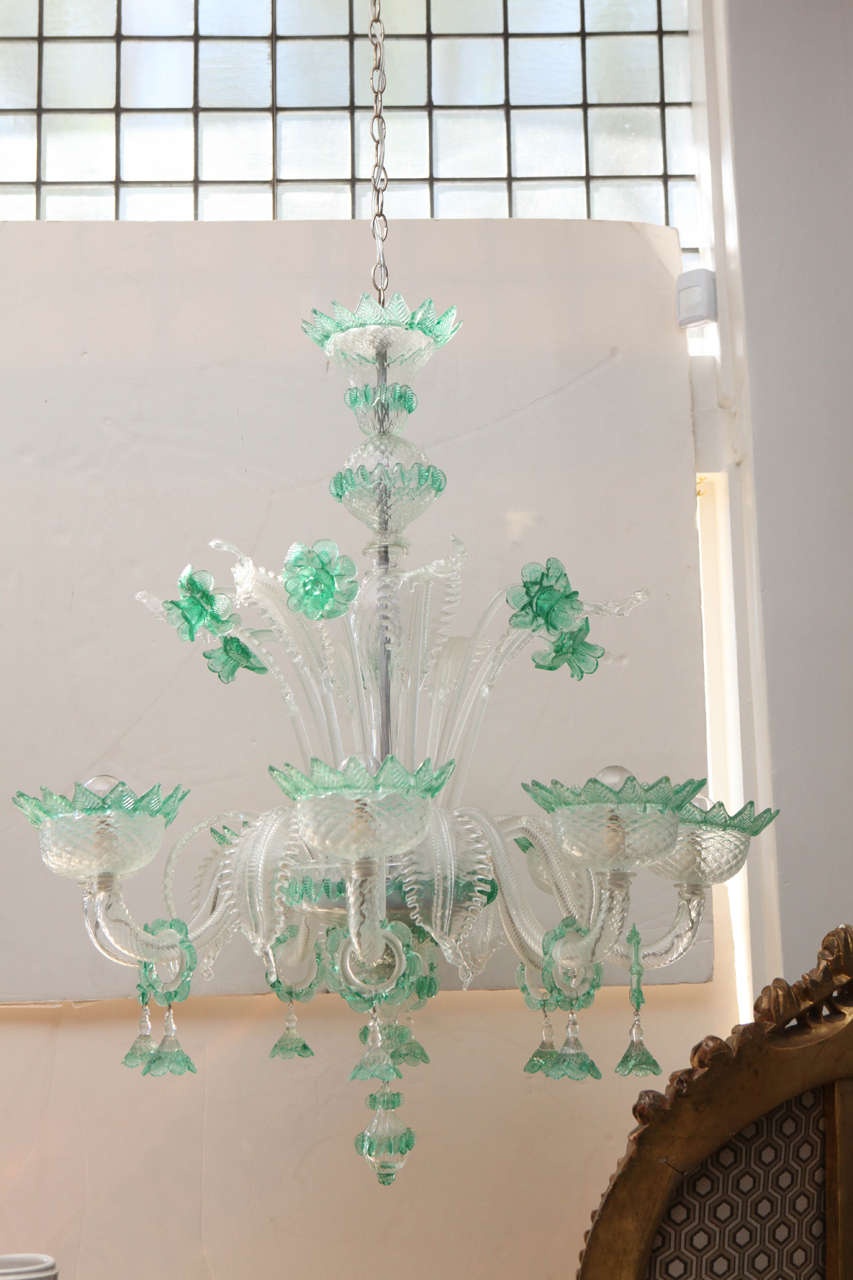 Exquisite vintage Italian handblown green glass chandelier with eight arms and dramatic Venetian style scrolling leaf, lily, and flower shade motifs, circa 1950s.