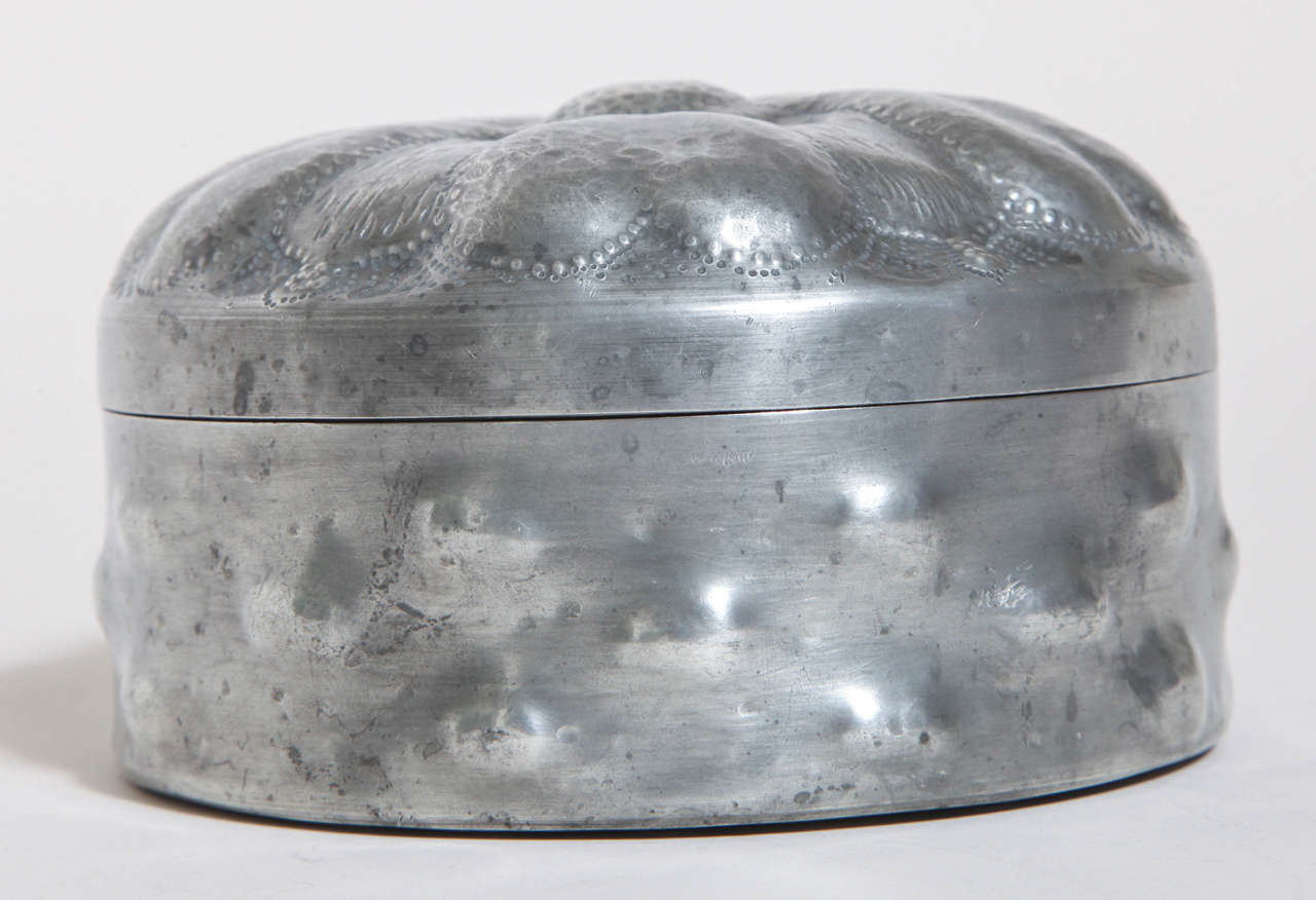 Pewter box with five heart-shaped lobes on top and protrusions around side. 

Signed Chanal