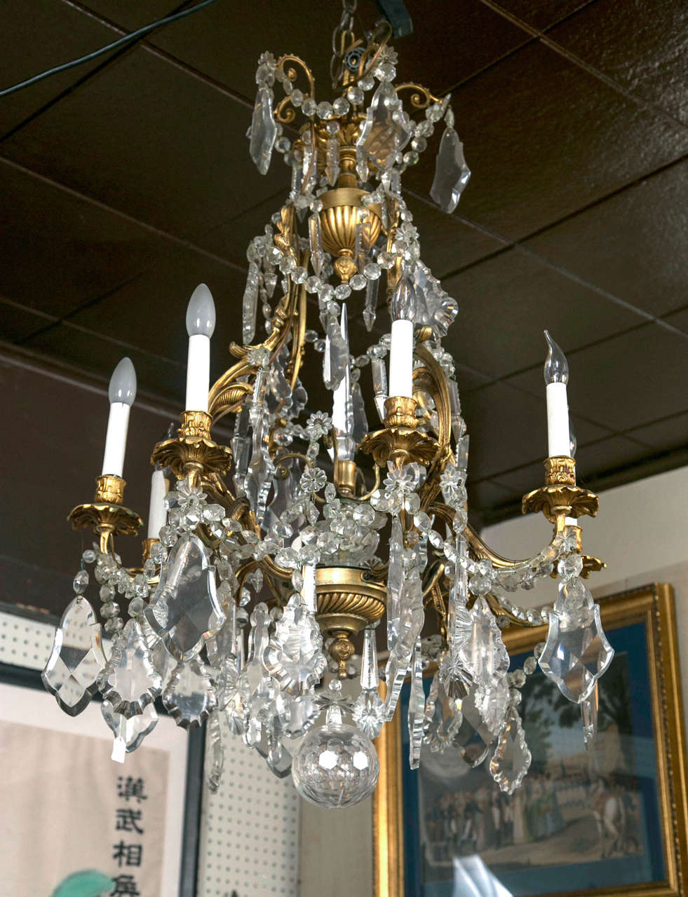 A Rococo chandelier with eight lights, with large crystal drops and swags. Large ball bottom finial. In working order.